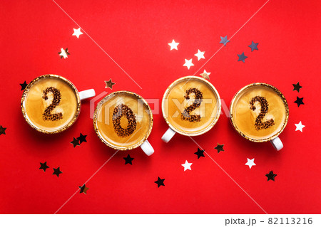New year 2022 is drawn on cups of coffee on red background 82113216