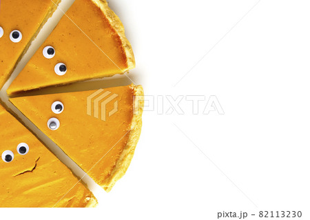 Slices of pumpkin pie in form of Halloween ghost with eyes on white isolated background with copy space. Festive creative food concept 82113230