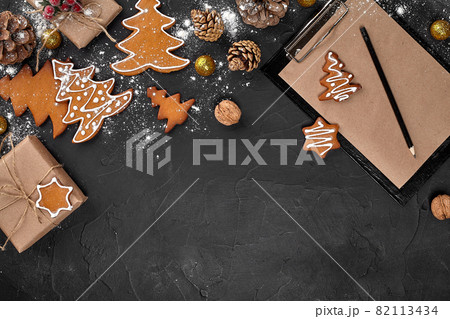 Christmas background with gingerbread cookies and craft sheets of paper. Copy space. 82113434