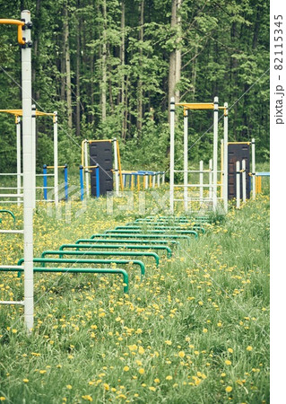 Sports ground with trainers on green lawn with flowers Sports ground with trainers on green lawn with flowers 82115345