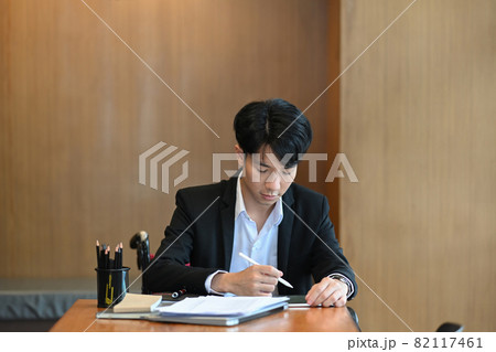 Handicapped man in wheelchair working in office. Handicapped man in wheelchair working in office. 82117461