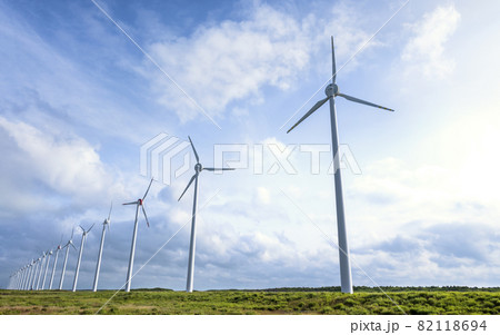 北海道で風を受けて回る一列に並んだ風車群 82118694