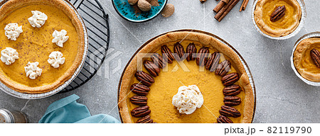 Pumpkin pie with cinnamon, pecan nuts and whipped cream for Thanksgiving, top view. Banner. 82119790