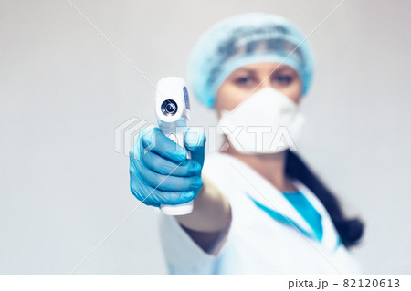 Measurement of body temperature with a non-contact thermometer. A woman doctor holds a modern Measurement of body temperature with a non-contact thermometer. A woman doctor holds a modern 82120613