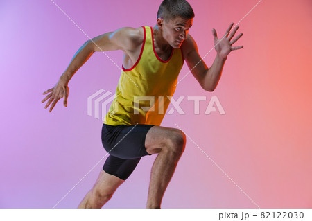 Cropped image of young professional male athlete isolated over gradient studio background. Marathon preparation 82122030