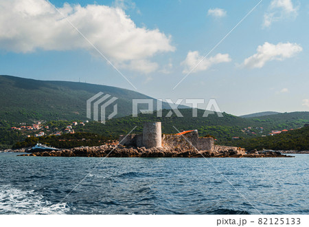 An island with the former Austrian fortress Arza. Mamula Island. In the background there is a mountain range, the Bay of Kotor, the Adriatic Sea. Close-up view from the sea from the yacht. 82125133
