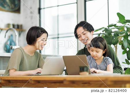 自宅のリビングでパソコンを見る家族 82126400