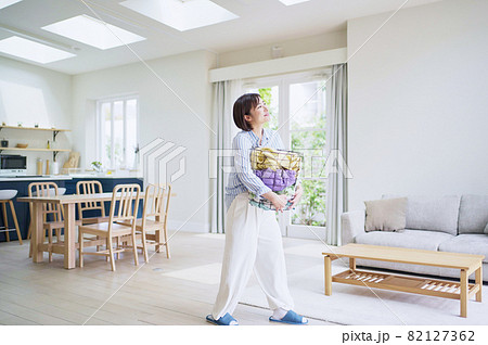 洗濯カゴを持つ若い女性 洗濯カゴを持つ若い女性 82127362