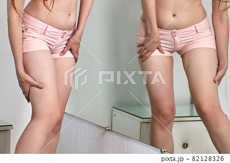During coronavirus lockdown woman checks how she has grown fat while staying at home. During coronavirus lockdown woman checks how she has grown fat while staying at home. 82128326