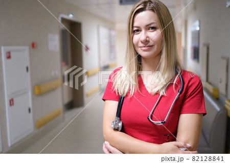 Young and attractive doctor on background of hospital corridor Young and attractive doctor on background of hospital corridor 82128841