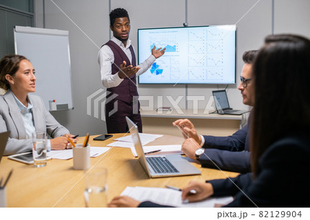 Young confident speaker or coach making report in front of audience 82129904