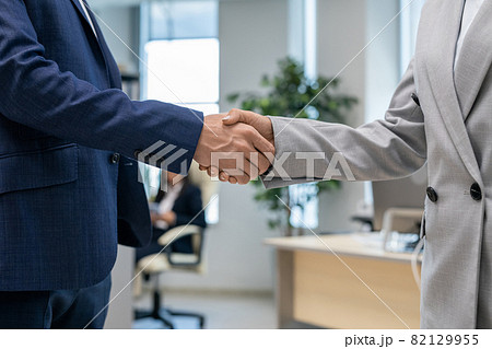 Handshake of two young business partners in office environment Handshake of two young business partners in office environment 82129955