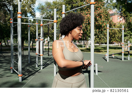Happy female in grey tracksuit exercising outdoors Happy female in grey tracksuit exercising outdoors 82130561