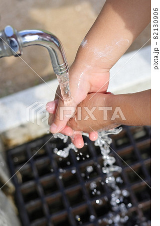 水道の蛇口で手を洗っている子供 82130906