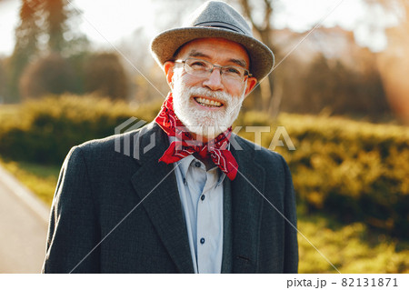 Elegant old man in a sunny autumn park 82131871