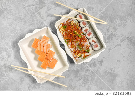 Tasty sushi rolls in disposable kraft paper boxes. Concept delivery service Japan food in eco container, flat lay 82133092