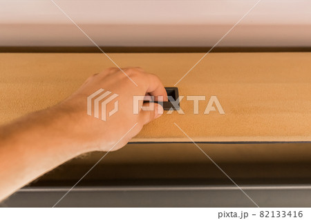 The guy's hand opens or closes the shelf for storing things in the cabin of the bus The guy's hand opens or closes the shelf for storing things in the cabin of the bus 82133416