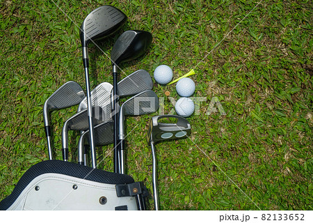 Closeup old golf bags on green. Set of golf clubs over green field background. Closeup old golf bags on green. Set of golf clubs over green field background. 82133652
