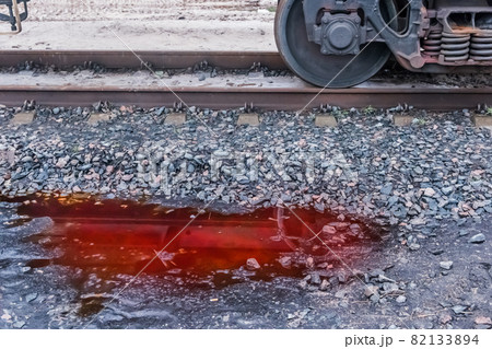 A puddle of red potash fertilizers after rain on crushed stones near the railway tracks on industrial plant A puddle of red potash fertilizers after rain on crushed stones near the railway tracks on industrial plant 82133894