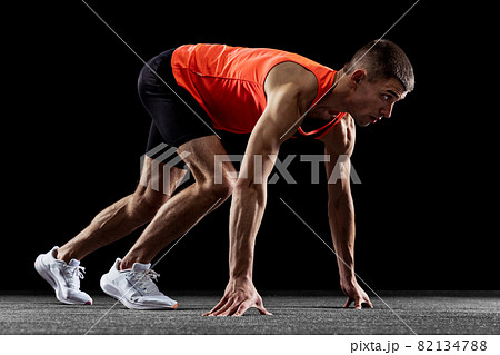 Young man, male athlete training isolated over black studio background. Side view 82134788
