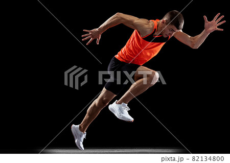 Full-length back view portrait of young male professional athlete running, training isolated over black studio background Full-length back view portrait of young male professional athlete running, training isolated over black studio background 82134800