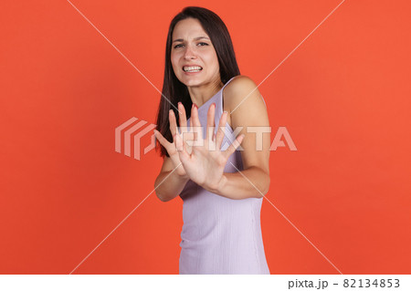 One beautiful caucasian girl posing isolated over red background. Keeping distance 82134853