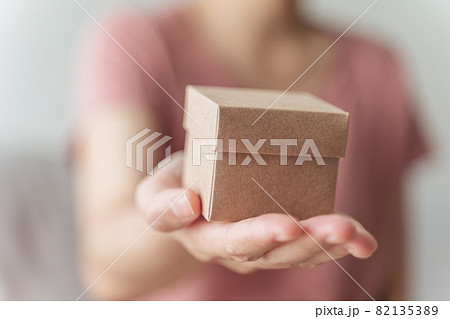 Close up of woman hands holding a small gift box. Small present box in the woman hands. Close up of woman hands holding a small gift box. Small present box in the woman hands. 82135389