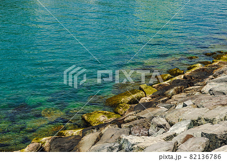 Close up of stones and clear water on the shore of a beach 82136786