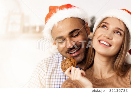 Cheerful attractive happy couple in Santa hats Cheerful attractive happy couple in Santa hats 82136788