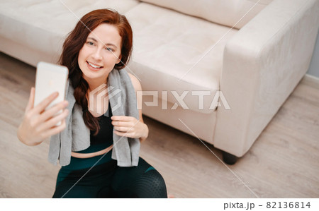 Young athlete takes a selfie after a fitness class at home in the living room. 82136814