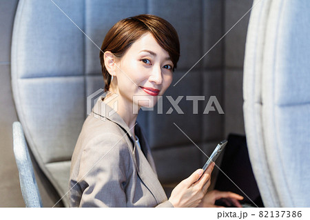 パーソナルブースでスマホを使う女性　撮影協力：WEEK芝大門（サンフロンティア不動産） 82137386