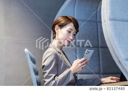 パーソナルブースでスマホを使う女性　撮影協力：WEEK芝大門（サンフロンティア不動産） 82137480