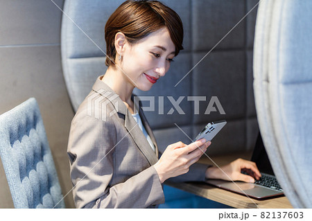 パーソナルブースでスマホを使う女性　撮影協力：WEEK芝大門（サンフロンティア不動産） 82137603