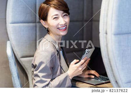 パーソナルブースでスマホを使う女性　撮影協力：WEEK芝大門（サンフロンティア不動産） 82137622