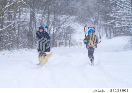 Two boys carry sledges on their shoulders to ride them down the slide, children and winter. Two boys carry sledges on their shoulders to ride them down the slide, children and winter. 82138901