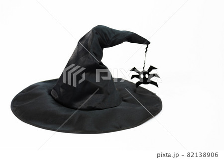 Black witch hat. Hat on a white background. A spider is attached to the hat. Witchcraft and magic. Concept Black witch hat. Hat on a white background. A spider is attached to the hat. Witchcraft and magic. Concept 82138906