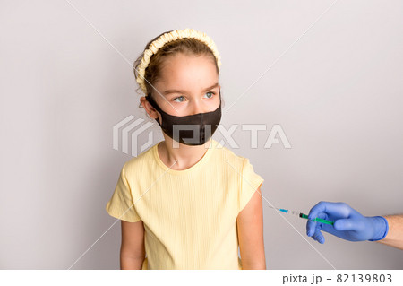 A nurse is giving vaccinations to patients with a syringe. White background. Close-up shot of injection against covid19. A nurse is giving vaccinations to patients with a syringe. White background. Close-up shot of injection against covid19. 82139803