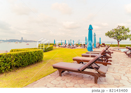 chair pool or bed pool and umbrella around swimming pool with sea beach background 82143400