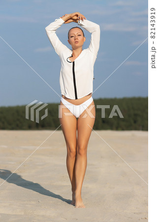 Dreamy young woman in white wear standing in nature 82143919