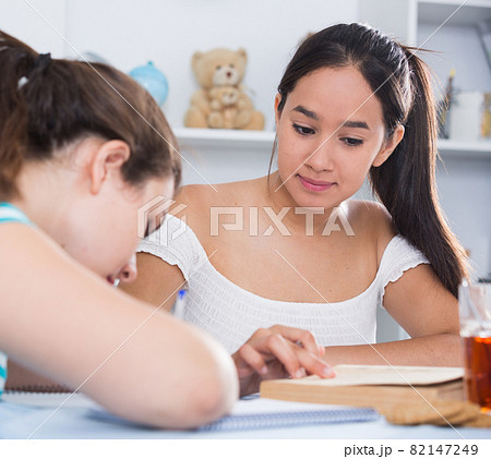 Two classmates doing homework together Two classmates doing homework together 82147249
