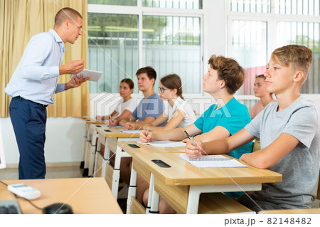 Pupils sitting in class and listening 82148482