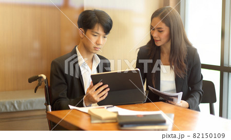 Asian female business manager coaching her new disabled person Asian female business manager coaching her new disabled person 82150109