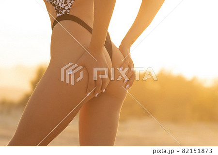 Crop woman with firm buttocks on beach Crop woman with firm buttocks on beach 82151873