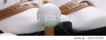 Golf boots, gloves and ball stand on green lawn 82152338