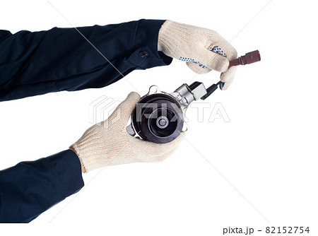 An auto mechanic holds a faulty car cooling system pump that drives coolant, white background, isolate. Regulations for replacing the auto pump 82152754