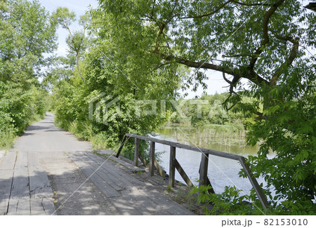 Beautifully standing old wooden bridge over river in colored background Beautifully standing old wooden bridge over river in colored background 82153010