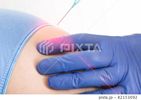 The doctor gives an anesthetic injection in the buttock for back pain. Spine treatment concept with intramuscular injections, chondroprotectors and B vitamins, close-up The doctor gives an anesthetic injection in the buttock for back pain. Spine treatment concept with intramuscular injections, chondroprotectors and B vitamins, close-up 82153092