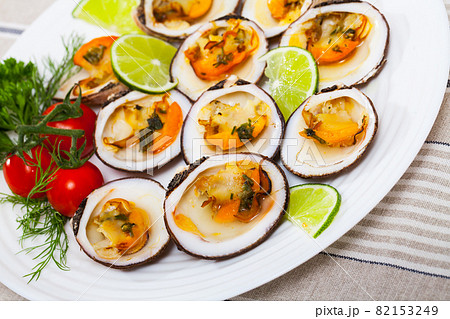 Baked in oven with sauce dog cockle with lemon and fresh greens 82153249