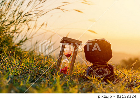 Hourglass and compass with sunrise in the morning at mountain 82153324
