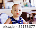 Sweet baby boy sitting at high chair in restaurant. Hotel vacation with child 82153677